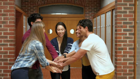 smiling students putting hands together