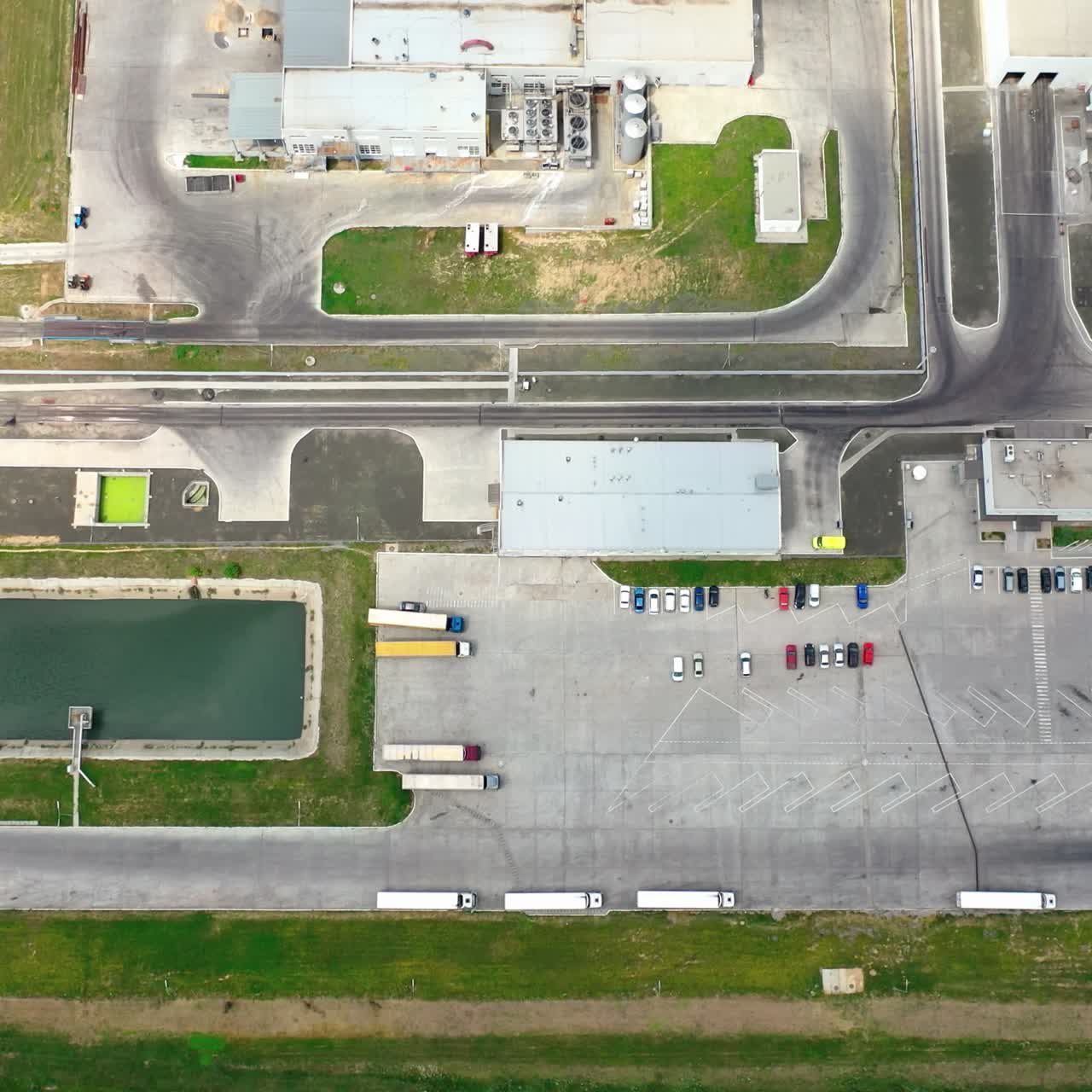 Industrial zone. View from above on a large industrial plant with car parking on field. Aerial view