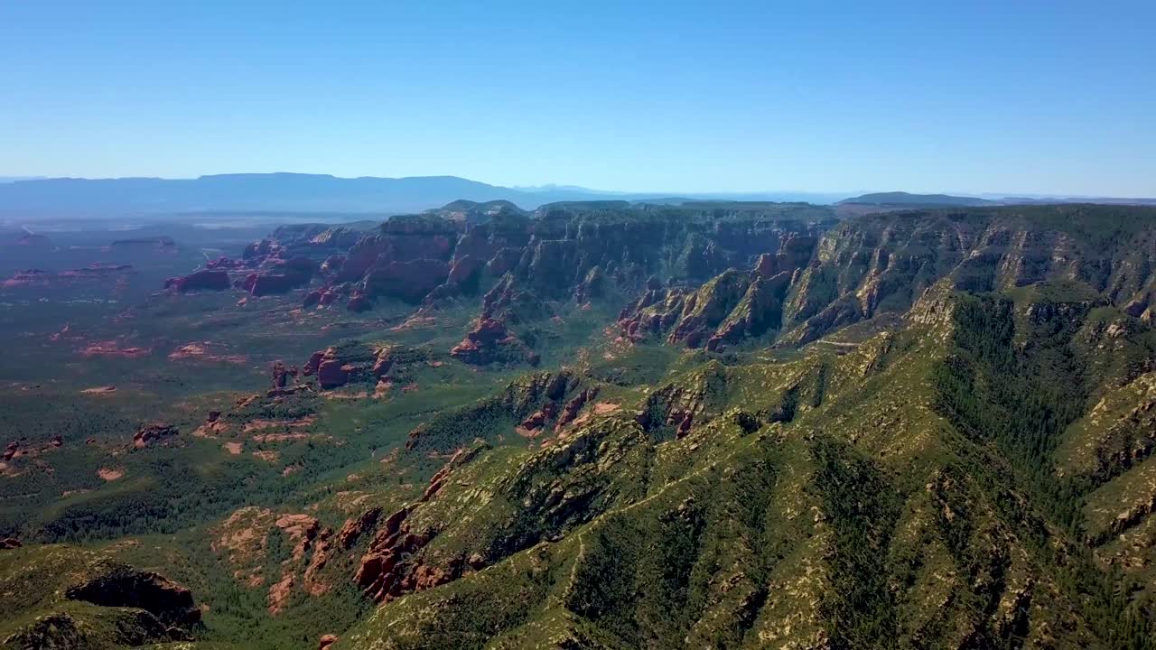 воздушная панорама горного каньона, покрытого лесом, с дымом от лесного пожара