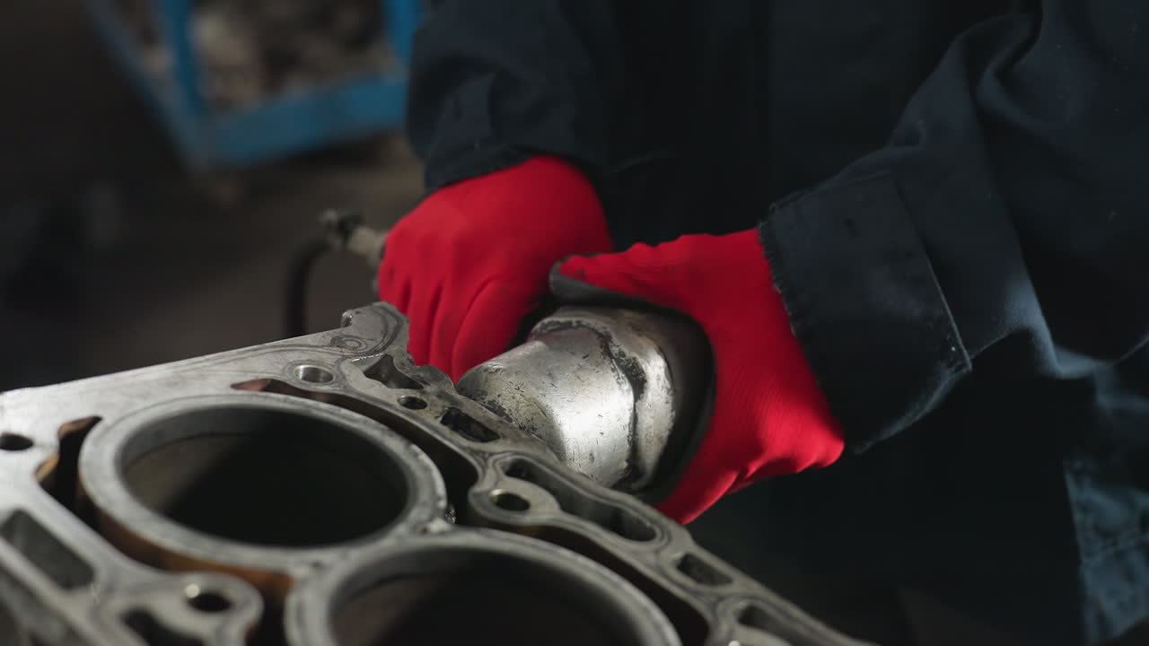 estudiante trabajando en una tableta mientras otro hombre se centra atentamente en una tarea en un taller industrial, el fondo presenta herramientas, equipos y espacio de trabajo mecánico