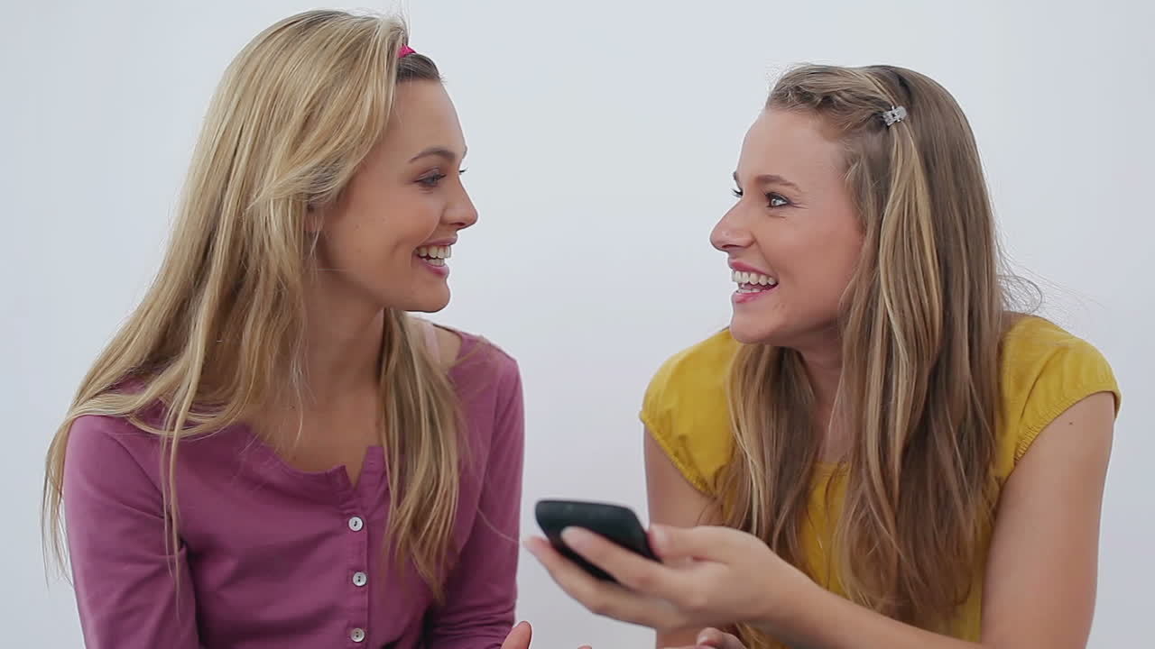 Two friends laughing after a phone call
