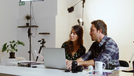 fotógrafos discutiendo sobre la computadora portátil en el escritorio 4k
