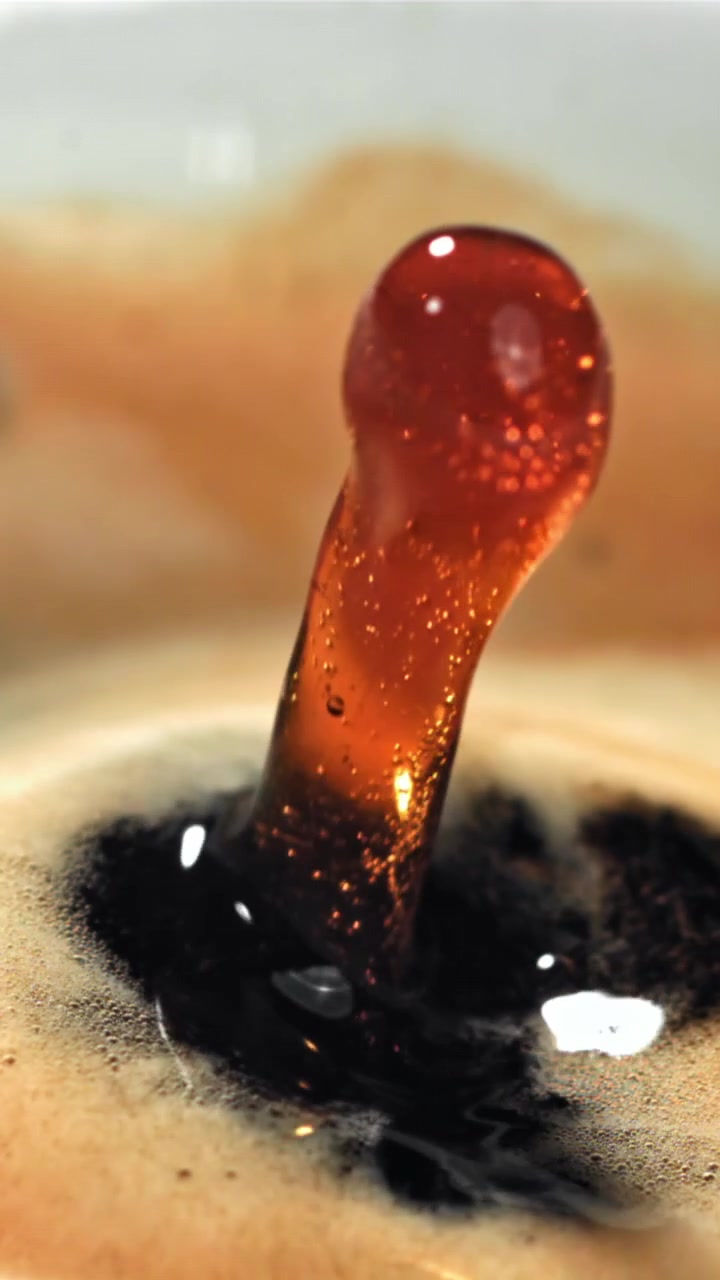Rallentatore dettagliato di una goccia di liquido che crea uno schizzo