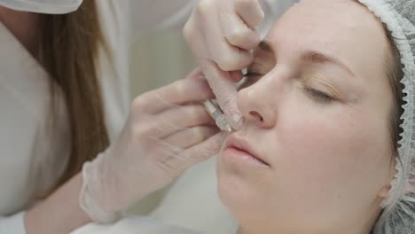 woman undergoing facial treatment at cosmetologist clinic