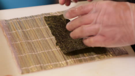 putting fresh seaweed and rice for a delicious sushi roll - close up