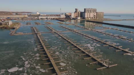 port colborne's industrial docks and ice-covered water in clear weather, static shot, aerial view