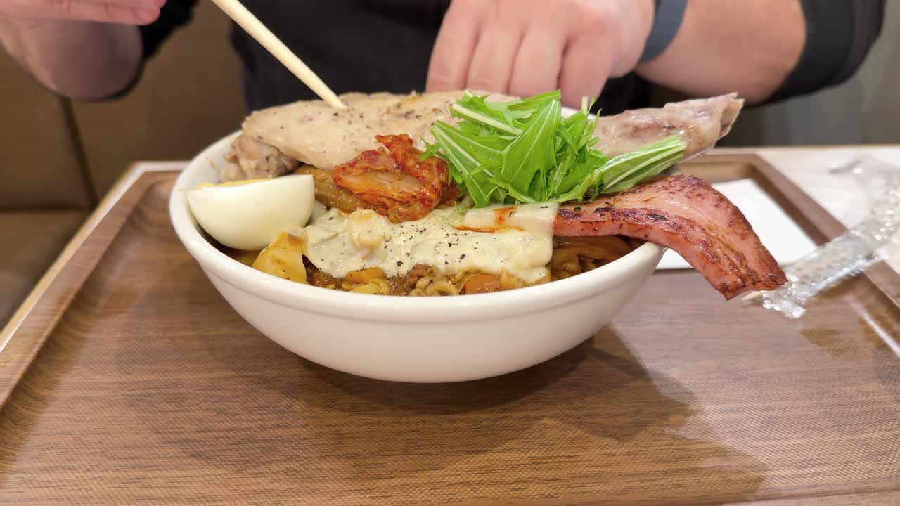 일본 가나자와에서 젓가락으로 국물 없는 라멘을 먹는 사람의 클로즈업 샷