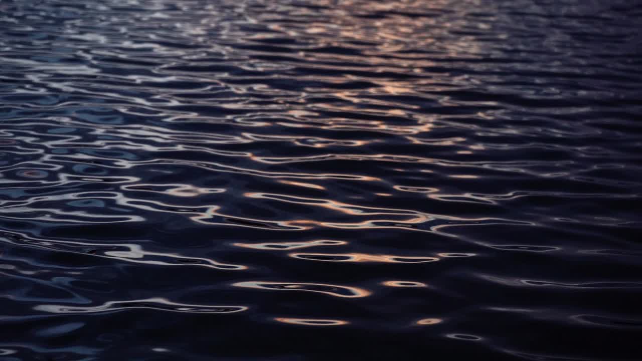 cámara lenta de profundas ondas oscuras con reflejo al atardecer