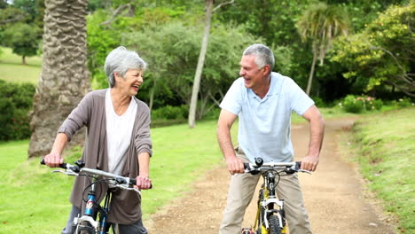 Retired-couple-in-the-park-riding-their-bikes