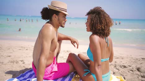 couple resting on beach at the ocean