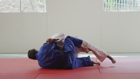 judokas luchando e inmovilizando en el suelo