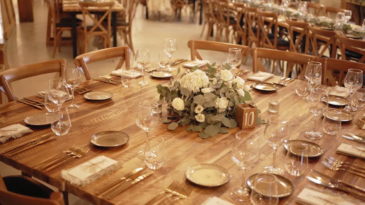 Elegant rustic wedding table set with floral centerpiece and wooden chairs