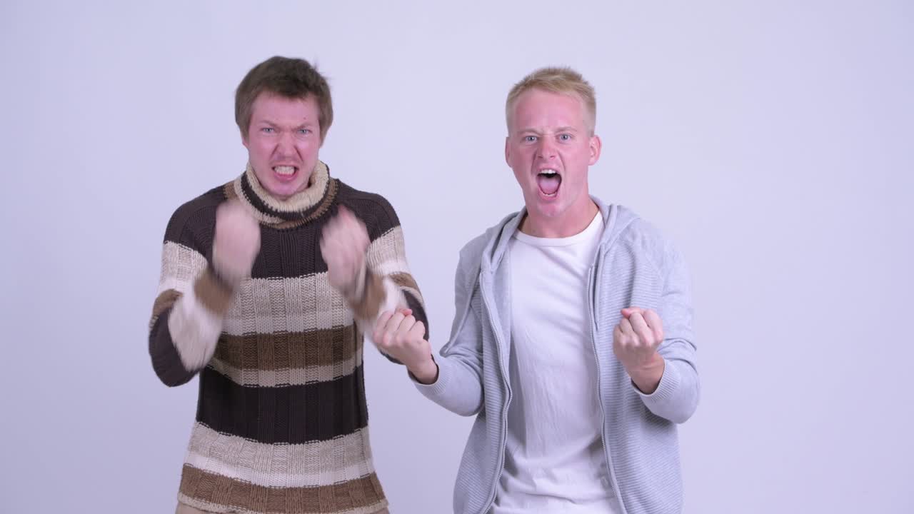 Two happy young men getting good news together