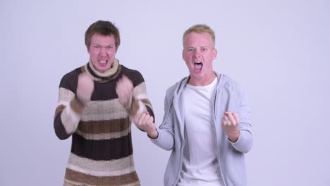 two happy young men getting good news together