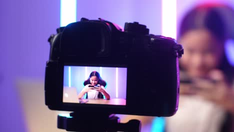 Display Camera Of Excited Asian Kid Girl Playing Video Game With Mobile Phone While Live Stream