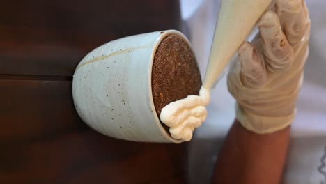 vertical footage: applying fresh cream on a coffee latte, close-up of the coffee cup