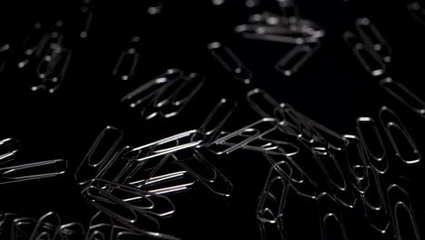 macro-dia die over paperclips is geschoten, meer paperclips die in slow motion naar beneden vallen