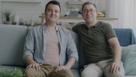 two men sitting on a sofa