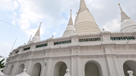 white pagoda under a cloudy sky in bangkok