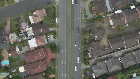 4k aerial dual carriageway or divided highway among the neighborhood homes, houses and properties with traffic drone forward top down fly over