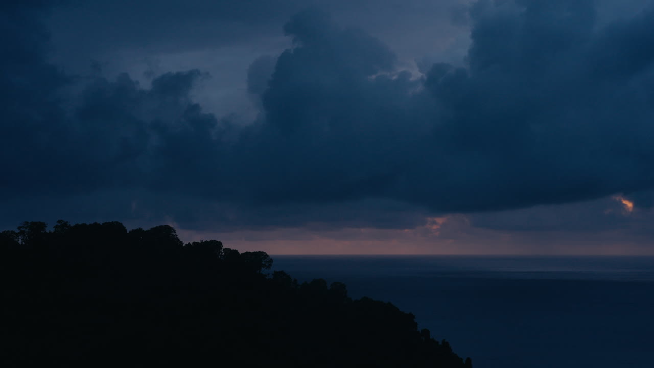 A scenic view of the sea and mountains at sunset