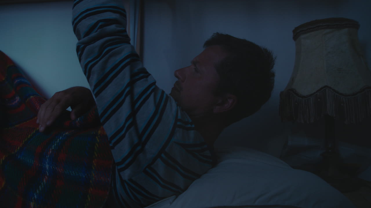 Man relaxing in bed at night