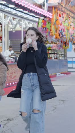Young woman enjoying cotton candy at a carnival