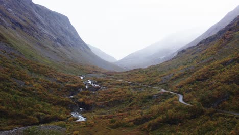 Flowing-River-With-Country-Road-In-The-Mountains-Of-Dovrefjell-Sunndalsfjella-National-Park,-Norway