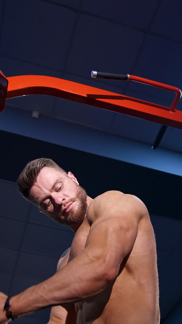 Muscular Man Working Out on Cable Machine in Gym