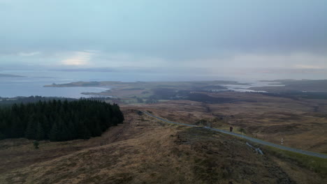 Seitliche-Lineare-Antenne-Der-Straße-Auf-Einem-Hügel-Mit-Lochs-In-Schottland