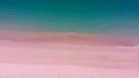 aerial view of a pink sand beach with turquoise water