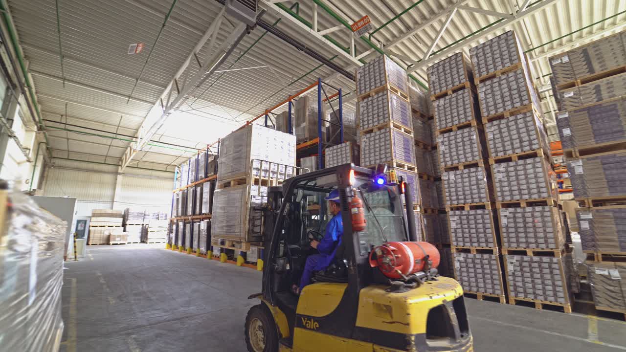 Empilhadeira entre os materiais no hangar. Armazenamento de pisos e parquet.