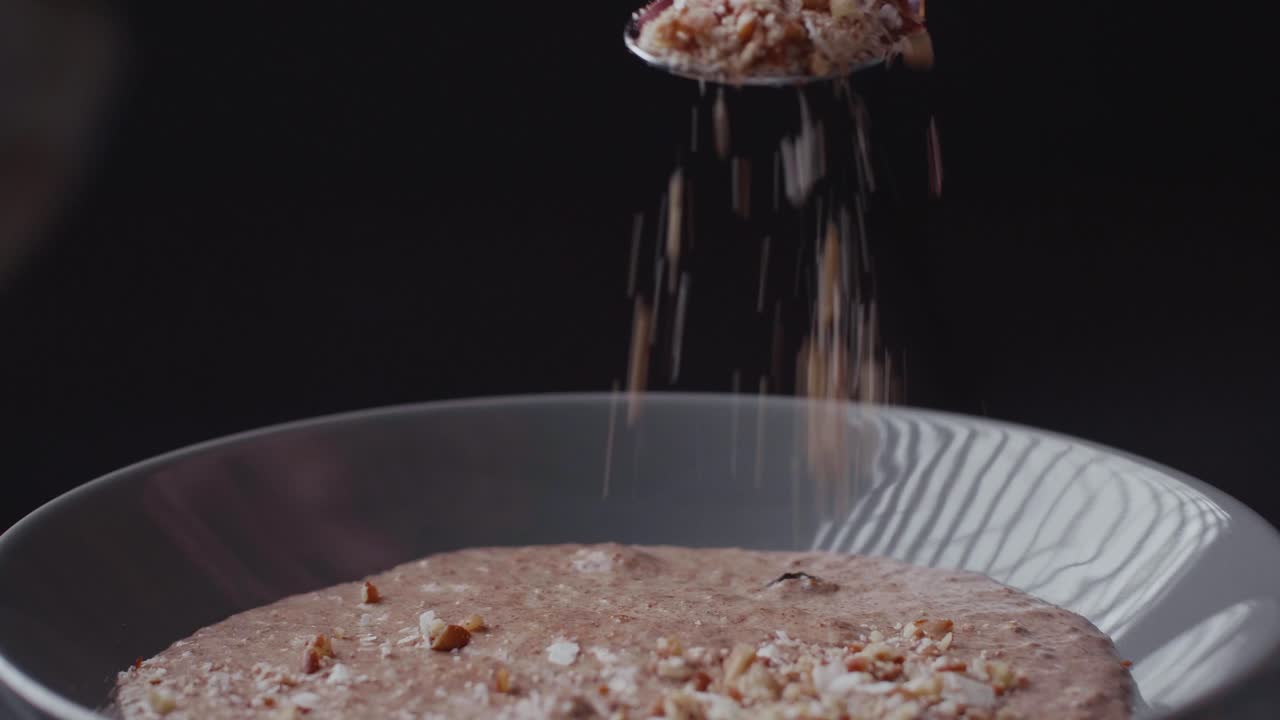 코코넛 밀크로 만든 팔레오 비건 치아 브렉퍼스트 죽 위에 견과류 뿌리기