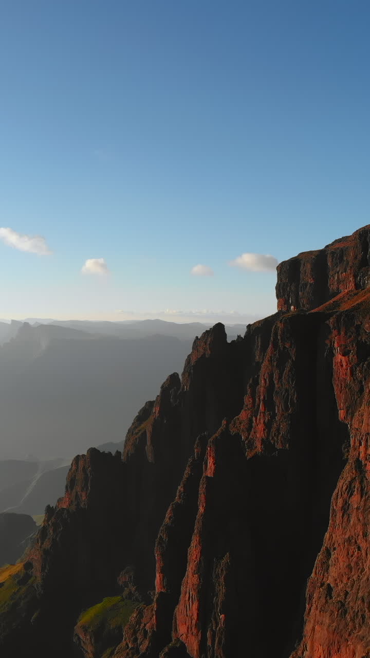 Imponenti pareti rocciose di montagna illuminate dalla luce dorata del sole
