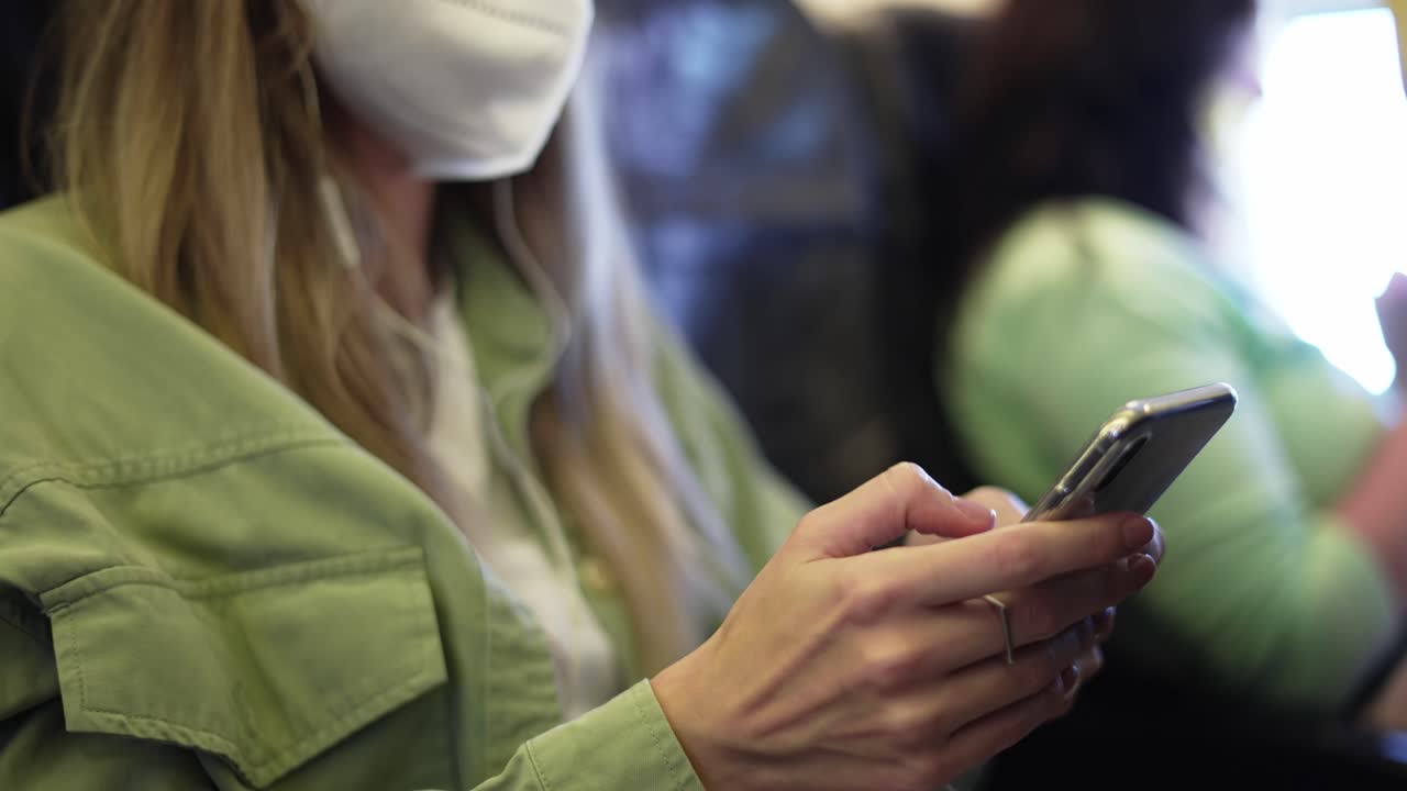 mujer turista de viaje en respirador blanco usando móvil en el avión, de cerca