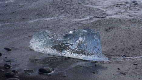 Primer-Plano-De-Un-Iceberg-En-La-Orilla-Del-Océano-Desbordado-Por-El-Agua-Del-Océano-En-Islandia