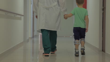 child and doctor walking in hospital hallway