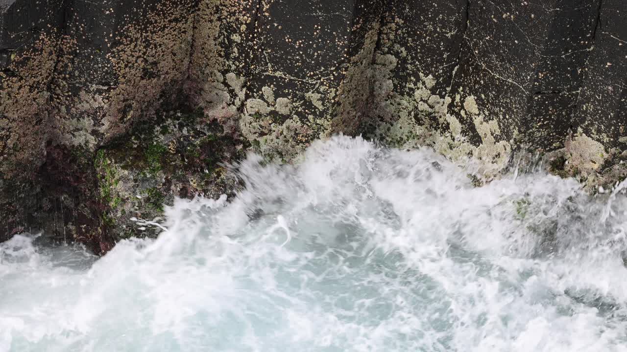 파도가 충돌하고 거친 해안선에서 물러납니다.