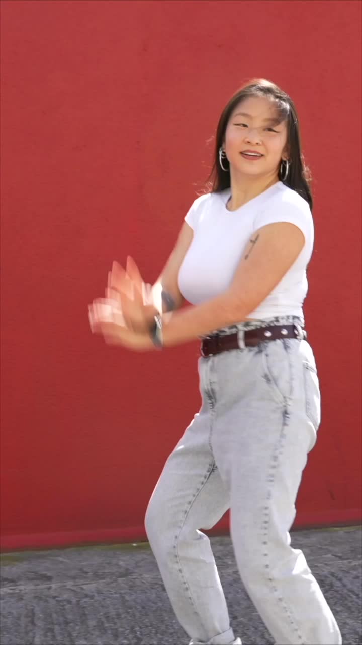 Woman dancing in front of red wall