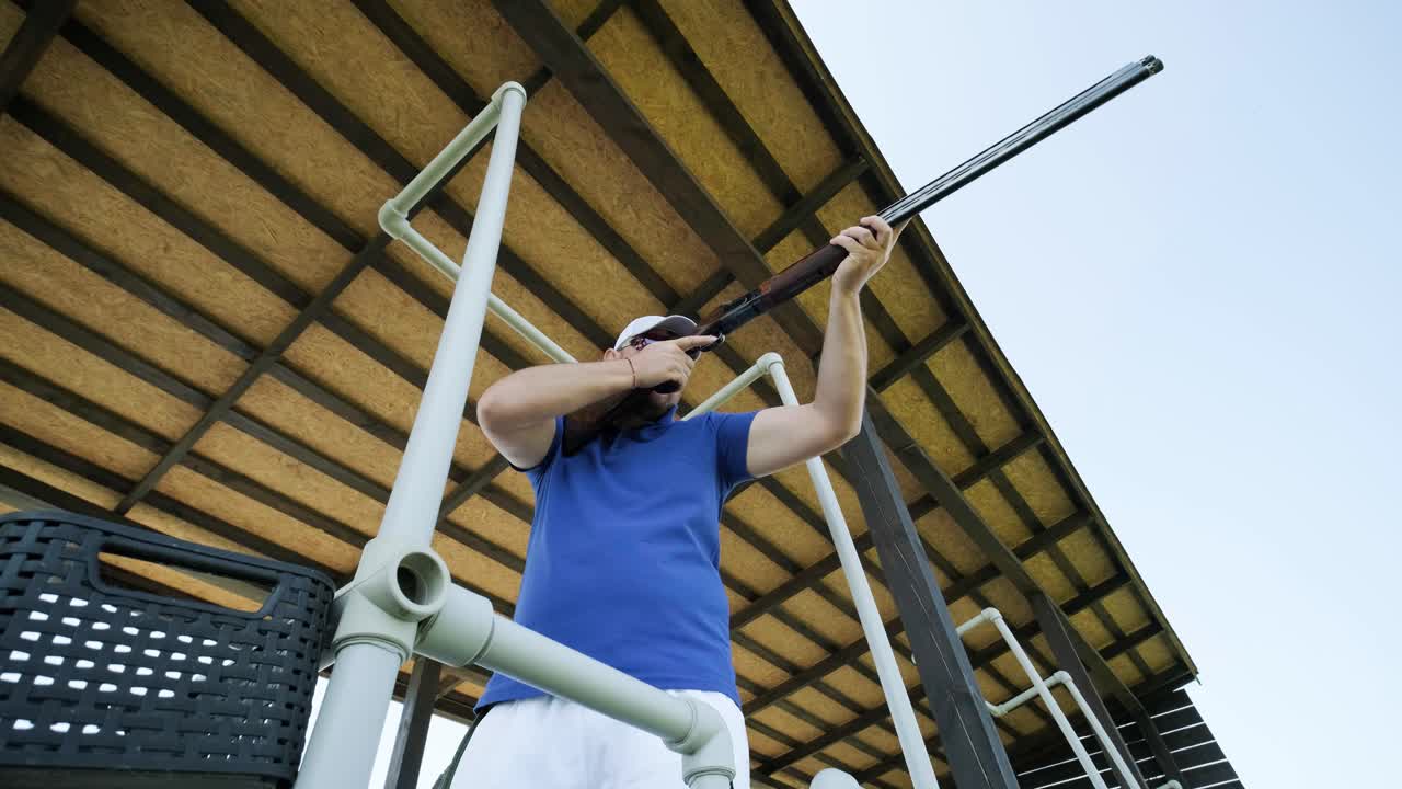 un deportista dispara con una escopeta de doble cañón, un campo deportivo para una prueba de tiro está disparando a un esquete volador