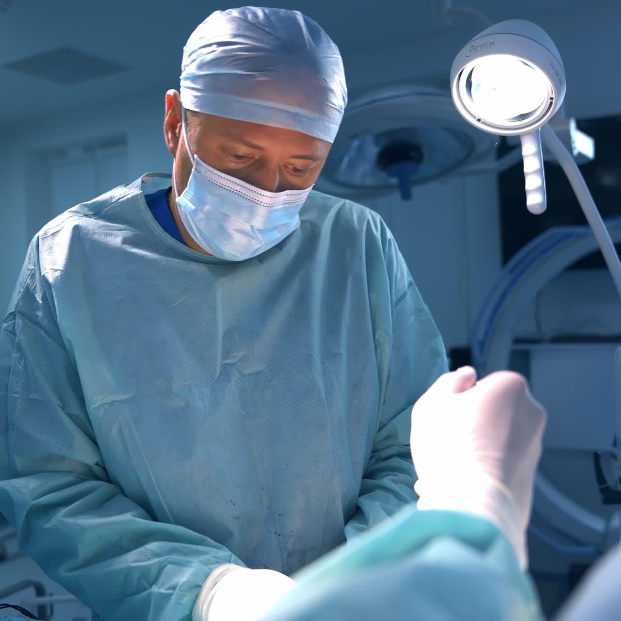 Chirurgo plastico che toglie un impianto dalla confezione. Medico che commenta qualcosa davanti alla telecamera. Ritratto di un chirurgo plastico.