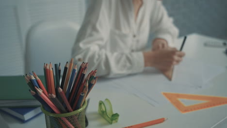 unrecognizable female teacher drawing triangles at her desk