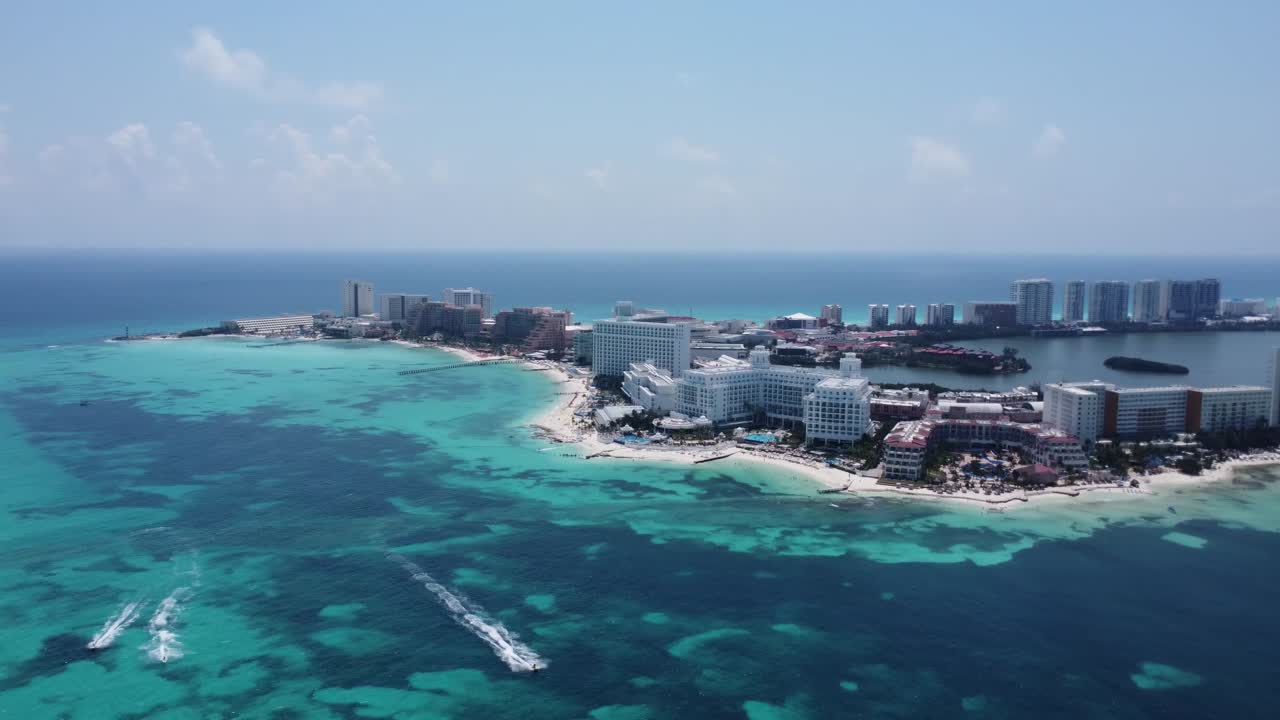 Rotating aerial over Cancun hotel zone, a haven for sun-seekers and vacation enthusiasts, stunning array of high-rise hotels and resorts that stand like beacons of luxury along the coast