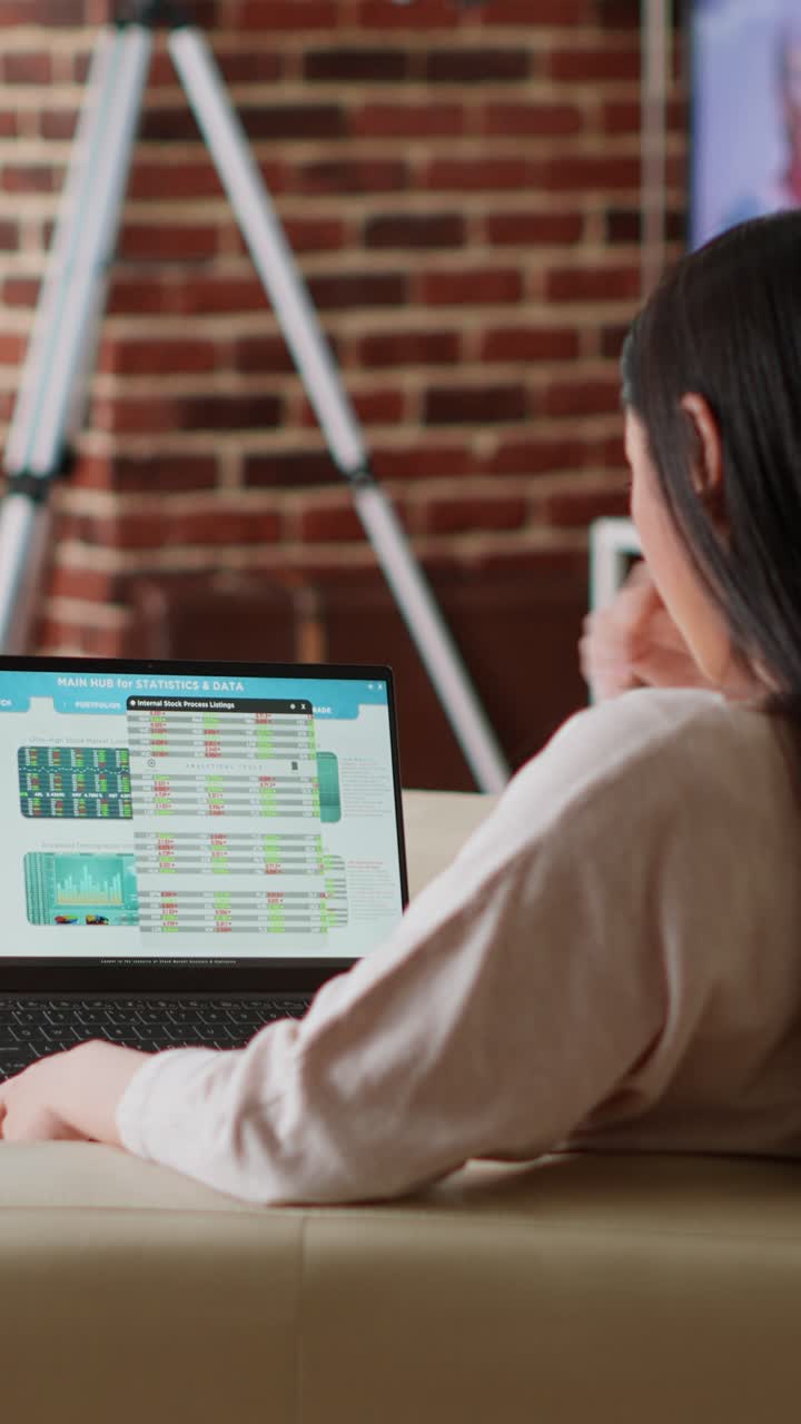 Wanita menganalisis data pasar saham di laptop di rumah