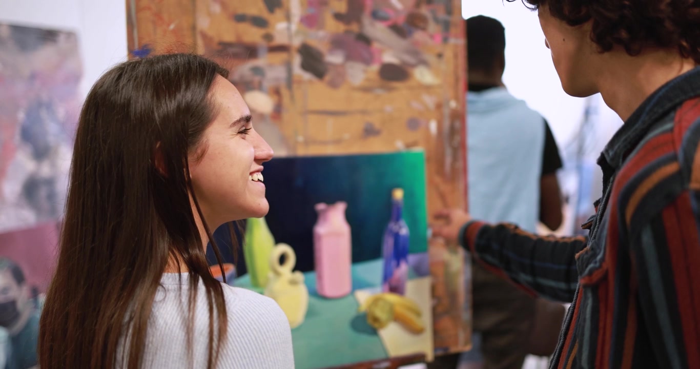 Giovani studenti d'arte che discutono un dipinto di natura morta in studio