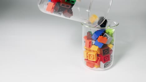 pouring lego bricks from one glass jar to another