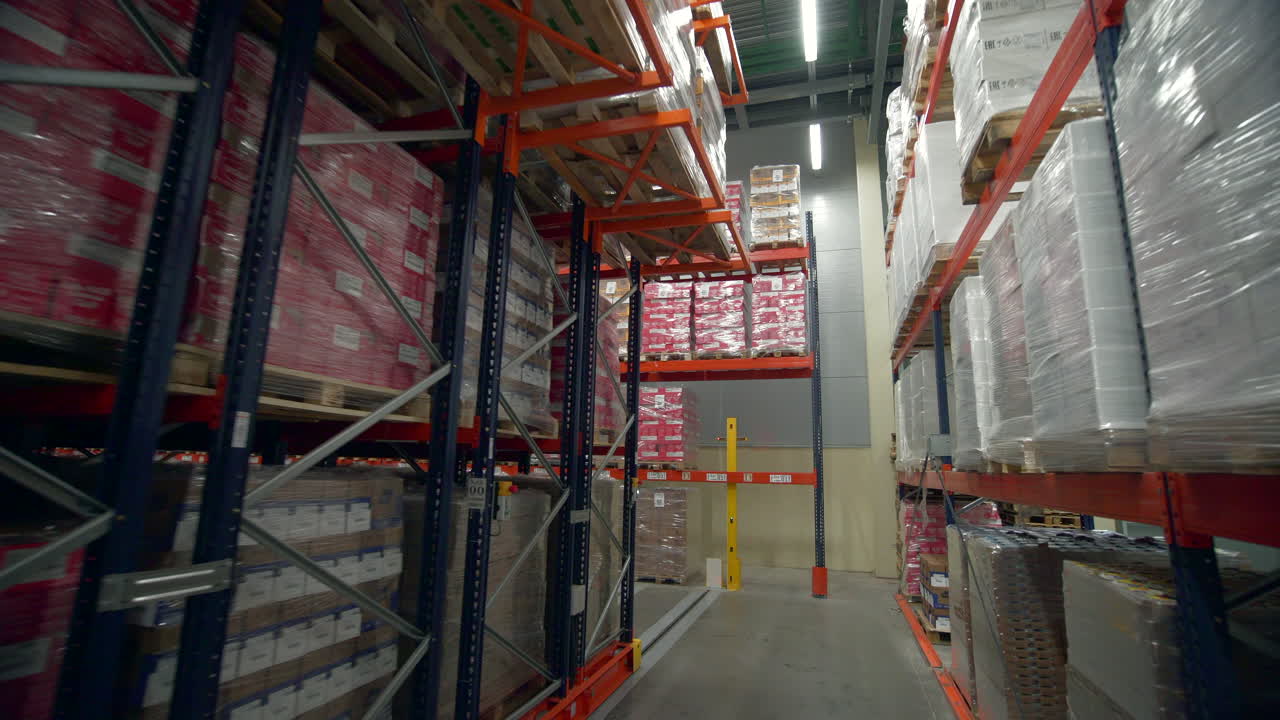 interior del almacén con almacenamiento de alta densidad y paletas de mercancías