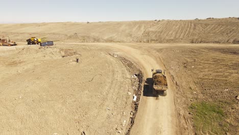 camión de carga que transporta tierra para preparar parcelas de vertedero, vista aérea de drones