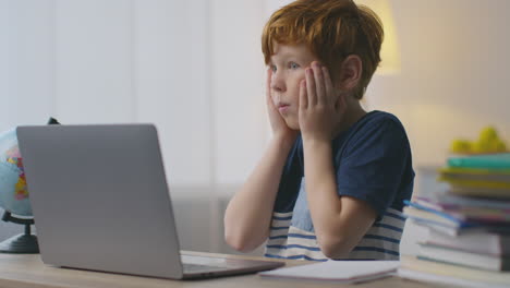 boy surprised by something on laptop