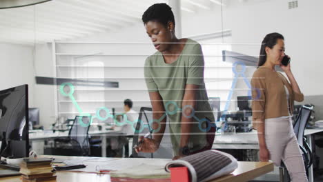 Animation-of-month-names-and-graph-over-african-american-woman-working-on-blueprint-in-office